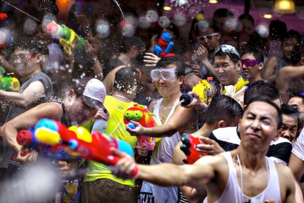 Revellers use water guns as they participate in a water fight during Songkran Festival celebrations at Silom road in Bangkok...Revellers use water guns as they participate in a water fight during Songkran Festival celebrations at Silom road in Bangkok April 13, 2015. The Songkran festival, also known as the water festival, marks the start of Thailand's traditional New Year and is believed to wash away bad luck. REUTERS/Athit Perawongmetha